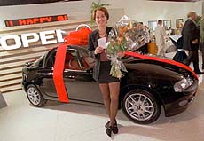 Swiss tennis star Martina Hingis poses with her new driver's license and her new Opel Tigra.