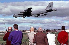 People watch one of a flight of six U.S. Air Force B-52 bombers land at the Royal Air Force base of Fairford, 120 km west of London, on Sunday. The bombers are being based in Britain for possible use in NATO action in Kosovo. 