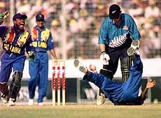 Sri Lankan wicketkeeper Romesh Kaluwitharana (left) appeals as Upul Chandana dives to take a catch and batsman Matthew Bell of New Zealand watches in the third encounter of the ICC Wills International Cup tournament in Dhaka on Monday. Bell was ruled not out by the umpire — AP/PTI