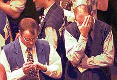 Traders react in share price index pit at the Sydney Futures Exchange during a break in hectic early trading on Tuesday. Following the American market fall overnight, the Australian sharemarket and futures also lost ground.