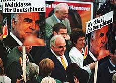 HANNOVER : German Chancellor Helmut Kohl (center) surrounded by election posters of himself saying: "Worldclass for Germany," walks through a crowd of supporters of his Christian Democratic Party during an election rally in Hanover, northern Germany, on Monday night. 