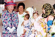 BANDAR SERI BEGAWAN: Queen Elizabeth II smiles at Bruneian mothers and their children at a maternity clinic near the traditional Kampong Ayer (water village) section of the capital city Bandar Seri Begawan on Friday. The Queen is on a four-day state visit to Brunei.
