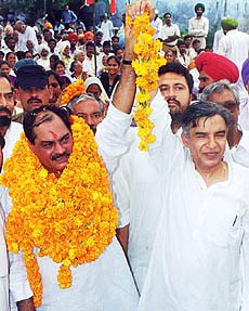 Mr Venod Sharma (left) waves to the crowd after taking over as president of the Chandigarh Territorial Congress Committee from Mr Pawan Kumar Bansal in Chandigarh on Friday — A Tribune photograph