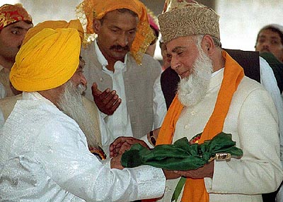 Pakistani President Rafiq Tarrar (right) receives a holy cloth from Diljit Singh, chief priest of Sikh community, in Lahore, Pakistan, on Sunday. Sikhs all over the world are observing their religious festival.
