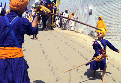 A young Nihang and a child playing gatka at a mohalla procession taken out by the Baba Bidhi Chand dal of the Nihangs at Anandpur Sahib on Thursday.