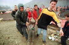 People carry a sick Kosovo refugee to a tent of the humanitarian organization "Medicines of the World" in the makeshift refugee camp near Blace,