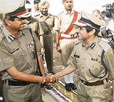 The new IG of the Chandigarh police, Dr Kiran Bedi, shakes hands with the outgoing chief R.P. Singh at his farewell parade 