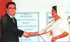 China's former premier Li Peng shakes hands with Bangladesh Prime Minister Sheikh Hasina