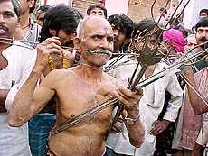 Hindu devotees with iron rods planted in their bodies