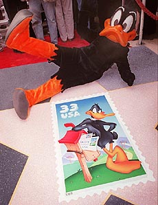 Daffy Duck poses outside Mann's Chinese Theatre in the Hollywood section of Los Angeles on Friday, with the newly issued postage stamp bearing his image. The U.S. Postal Service will print four hundred million of the new self-adhesive, 33-cent stamps.
