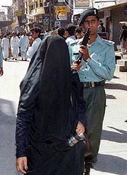 Policeman patrols on the alert as Shiite Muslim procession passed by in Lahore on Monday. 