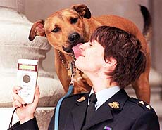 Royal Society for the Prevention of Cruelty to Animals Inspector, Jackie Paradis holds a reading device during a photocall in London, Tuesday August 3, 1999, with RSPCA dog Attilla, to launch the Passports for Pets scheme. 