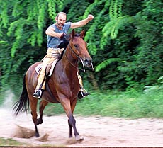 Miklos Pinter a member of the local Sitting Bull Western Equestrian Club of Hungary punches the air atop his horse Sherry as he breaks the world record for one day's long distance ride at the lake of Fot, some 10 kms north of Budapest, Hungary, Saturday