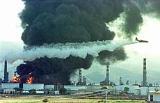 A plane drops water over the Tupras oil refinery
