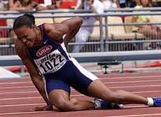 Marion Jones of the United States lies injured on the track after pulling up injured in her Women's 200 meters semi-final at the seventh World Track and Field Championships in Seville's Olympic Stadium, Wednesday. 