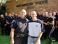 Jim Kautz, left front, a detective with the Westminster, Colo., Police Department, stands with his 19-year-old son, Brian, to show off their shaved heads along with 57 other Westminster officers who had their locks shorn early Wednesday, Aug. 25, 1999, to support Brian Kautz in his battle against a rare form of muscle cancer in the northwest Denver suburb. 