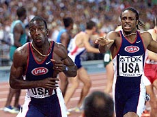 U.S. sprinter Michael Johnson, left, takes of running after receiving the baton from team mate Angelo Taylor, right, during the men's 4 x 400-metre relay event, won by the U.S., at the seventh World Track and Field Championships in Seville, Spain, on Sunday