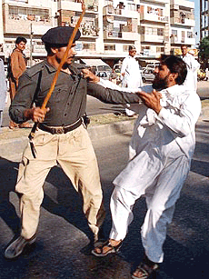 A policeman beats a supporter of Nawaz Sharif