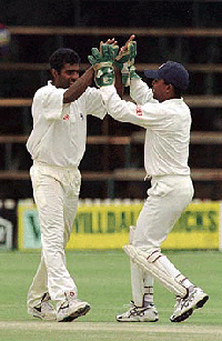 The Sri Lanka wicket keeper congratulates bowler Muttiah Muralitharan for getting out Zimbabwe's Murray Goodwin, caught Arnold for 38 runs on the last day of the third test match at the Harare Sports Club on Wednesday.