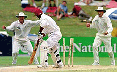 West Indies' batsman Sherwin Campbell (centRE) looks back to see the bails flying after being bowled by New Zealand's Chris Cairns for 0 on the fourth day of their first cricket test in Hamilton, New Zealand on Sunday