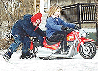 Monica Milliner (7) pulls Taylor McClanahan(6) on the battery-operated Harley Davidson bike near Marion, Ind., on Monday. McClanahan got the bike as a Christmas gift