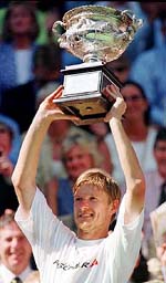 Yevgeny Kafelnikov raises his trophy after winning the men's final at the Australian Open Tennis Championships