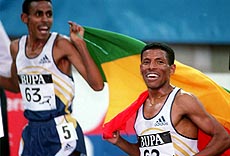 Ethiopia's Haile Gebrselassie (right) celebrates after he smashed his 15th world record with an astounding run in the 5000 metres at the BUPA Indoor Grand Prix in Birmingham on Sunday.