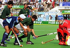 Pakistani goalkeeper, Moahmmad Qasim (right) defenders Saqlain (second from right) and Danish Kaleem (left) try to stop Indian forward Baljit Singh Sani from scoring at National Hockey stadium in Lahore on Tuesday. 