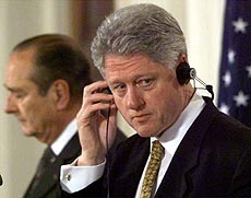 President Clinton listens on a headset Friday during a White House joint news conference with French President Jacques Chirac (at left). 