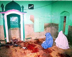 Two relatives sit in the mosque where 16 Shiite muslims were killed.