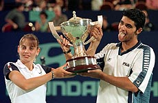  PERTH : Mark Philippoussis sticks out his tongue as he and teammate Jelena Dokic hold the Hopman Cup after they defeated Sweden to win the international mixed teams championship in Perth, Australia on Saturday. The Australian's beat Sweden 2-0 to take the tournament. AP/PTI