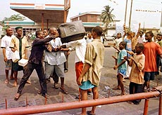 People fight over scarce supplies of kerosene.