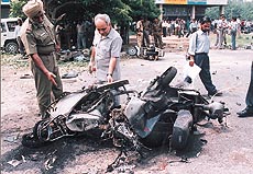 A forensic expert examines the mangled remains of two-wheelers damaged in a major blast in Sector 34 of Chandigarh on Wednesday