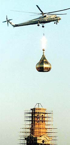 A helicopter air lifts an onion dome with cross on to the tower of the cathedral in downtown Rostov-on-Done, Russia.