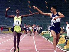 Morocco's Hicham El Guerrouj, right, celebrates as he clocks the new men's mile world record time of 3 minutes 43.16 seconds, during the Golden Gala athletics meeting at Rome's Olympic stadium Wednesday