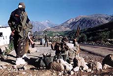 A fully-armed jawan keeps a watch on the strategic "Tiger Hill" peak, as the others take rest in the Dras sector.