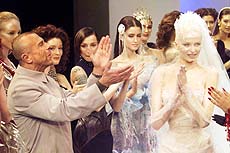 Designer Thierry Mugler (left) applauds his models following his Haute Couture fall-winter 1999/2000 collection presentation in Paris on Tuesday.