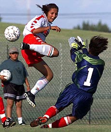 Mexican midfielder Fatima Leyva Moran (left) flies through the air as she tries to shoot past Canada's goalkeeper Karina Leblanc during Pan American Games women's soccer action in Winnipeg, Manitoba, Canada on Tuesday