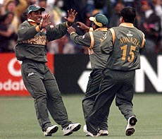 Bangladesh's captain Aminul Islam (centre) congratulates Shahriar Hossain (left) after he caught Pakistan's captain Wasim Akram for 29 bowled by Minhajul Islam (15) during the Group B Cricket World Cup game between Pakistan and Bangladesh