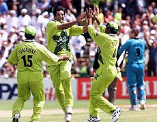 Pakistan's captain Wasim Akram (centre) is congratulated by teammates after bowling New Zealand's Craig McMillan caught Moin Khan during the Cricket World Cup Semi final match