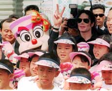 American pop superstar Michael Jackson poses a victory sign with South Korea's orphans and disabled children