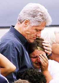 American President Bill Clinton comforts a resident of the Brazda refugee camp in Macedonia