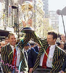 Australian cricket vice-captian Shane Warne (left) and captain Steve Waugh hold the World Cup trophy during a celebration parade in Melbourne on Wednesday