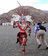 The first runner, dressed in Aztec outfit, leaves the Pyramid of the Moon, behind, carrying the torch of the Pan American Games Wednesday