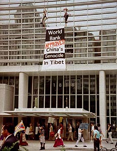 Members of a Tibetan activist group scale the front of the World Bank headquarters in Washington on Friday unfurling a banner protesting the organization's decision to approve a loan to resettle Chinese farmers on land Tibetains claim is theirs.