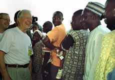 Former US President Jimmy Carter talks with Nigerian voters as they line up to cast their ballots in the presidential elections in Abuja, Nigeria on Saturday. 