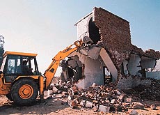 A bulldozer of the Chandigarh Administration demolishes a newly-constructed house in Kajehri village in Chandigarh on Wednesday. 