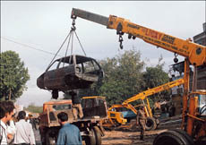 Cranes of the Enforcement Wing of the Municipal Corporation hoist vehicles parked by motor mechanics at public places in Sector 28, Chandigarh, on Monday morning
