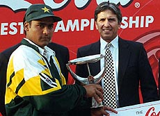 Majid Khan (right) former Pakistani Test cricketer giving away the Man of the Match trophy to Pakistan's Wajhatullah Wasti for his best performance against Sri Lanka in the Asian Test Cricket Championship played at Gaddafi stadium in Lahore on Monday.
