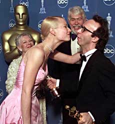 Best actress winner Gwyneth Paltrow, who won for her role in "Shakespeare in Love," gives best actor winner Roberto Benigni, who won for his role in "Life is Beautiful," a kiss backstage at the 71st Annual Academy Awards